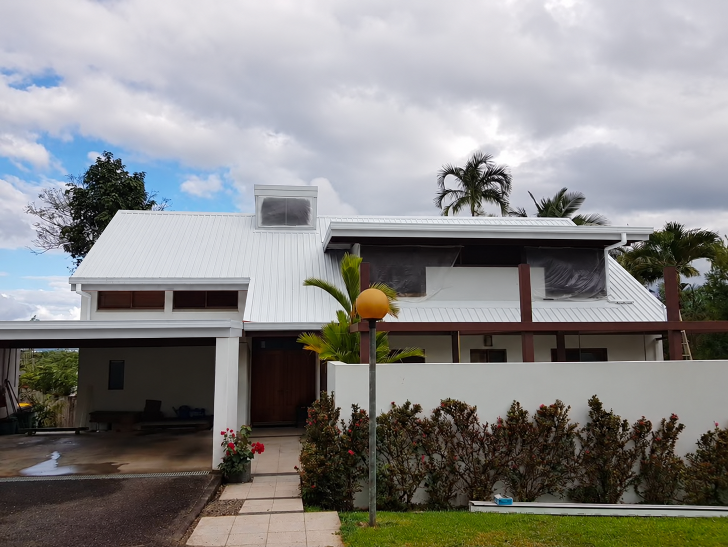 Tropical house with a white roof and digitally whitened gutters